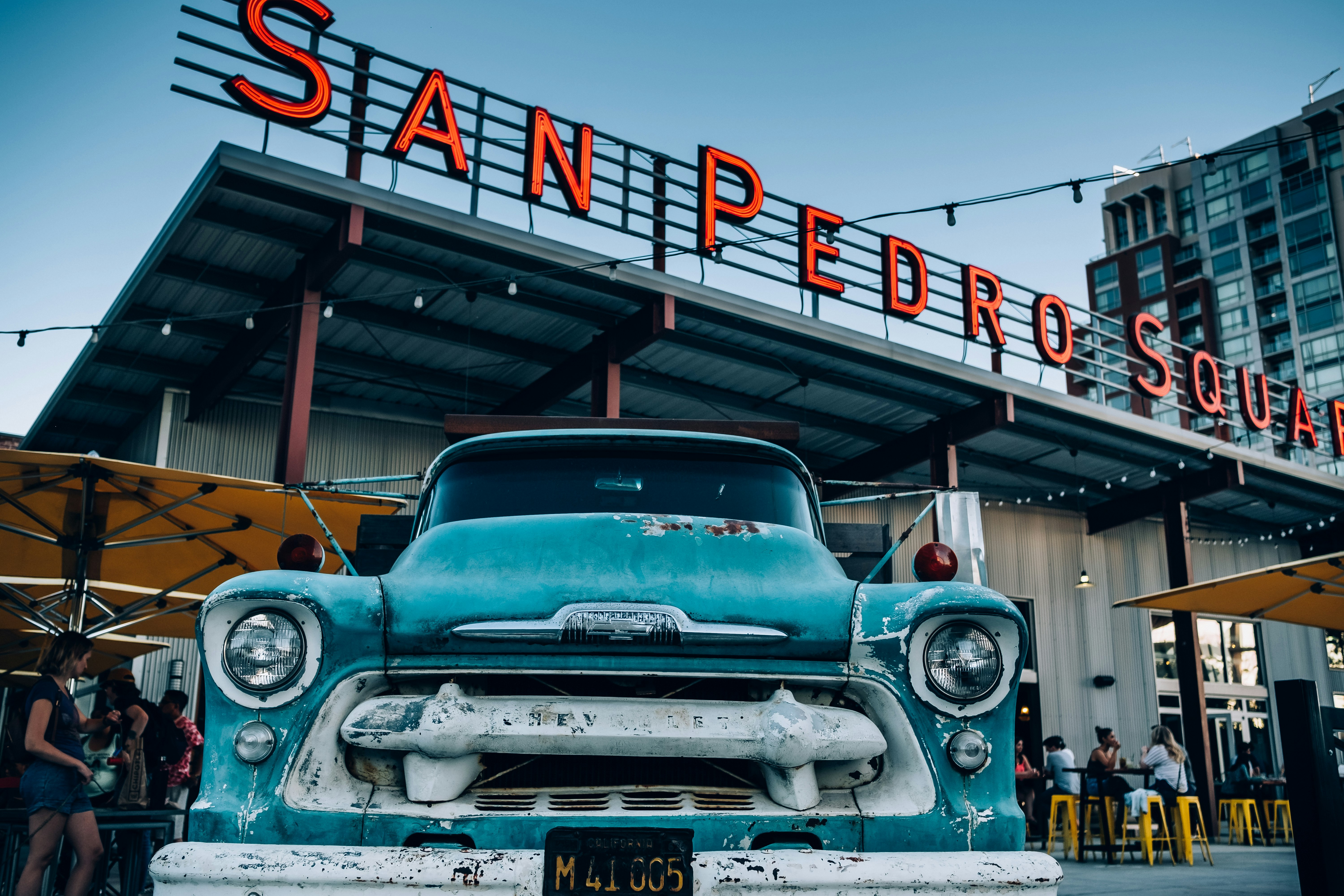 blue classic car parked in front of San Pedro Square